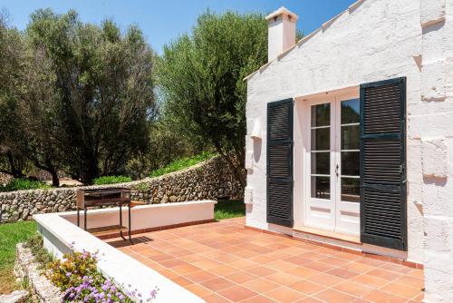 a patio with a bench in front of a building at Casa Nova de Biniparrell in Sant Lluis