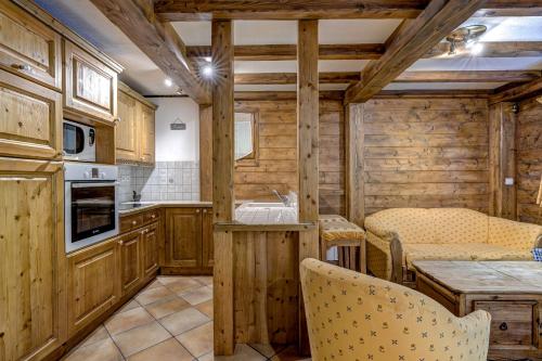 une cuisine avec des armoires en bois et une table et des chaises dans l'établissement Jardin du Parc Mont Blanc- Alpine Style apartment in the Heart of Chamonix, à Chamonix-Mont-Blanc