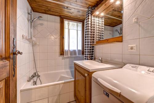 une salle de bain avec une baignoire et un lavabo et une baignoire dans l'établissement Jardin du Parc Mont Blanc- Alpine Style apartment in the Heart of Chamonix, à Chamonix-Mont-Blanc