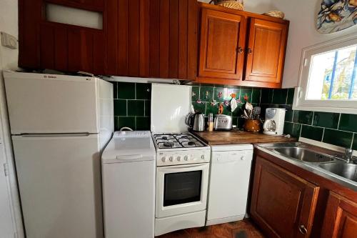 une cuisine avec des appareils électroménagers blancs et des armoires en bois dans l'établissement Fisherman house - 16m-mooring and a wonderful panoramic, à Grimaud