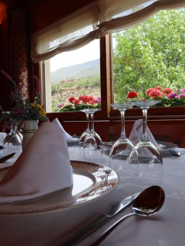 a table with glasses and napkins on a table with a window at Hotel La Morera in Valencia de Aneu