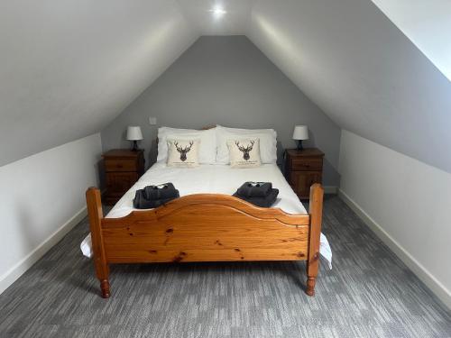 a bedroom with a wooden bed in a attic at 3 Dialknowe Holiday Cottage - Wanlockhead - 3 Bedrooms in Wanlockhead