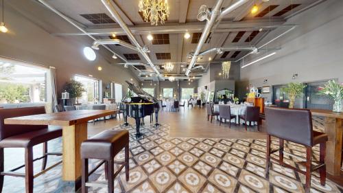 a restaurant with tables and chairs and a grand piano at Bellevall resort, hotel y apartamentos in Aspe