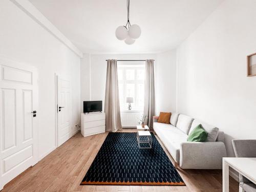 a white living room with a couch and a tv at Luxury Design Apartments - Poznańska Warsaw City Center in Warsaw