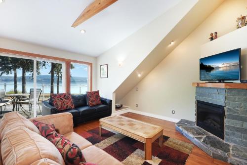 a living room with a couch and a fireplace at Buckley Bay Beach House in Courtenay