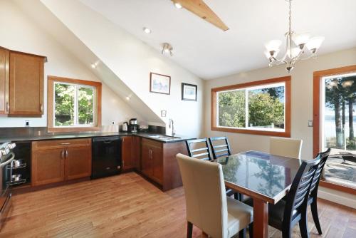 a kitchen and dining room with a table and chairs at Buckley Bay Beach House in Courtenay