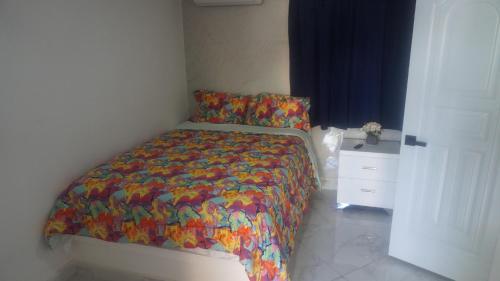 a bed with a colorful comforter in a bedroom at Aparta Hotel Ana Julia in Sosúa