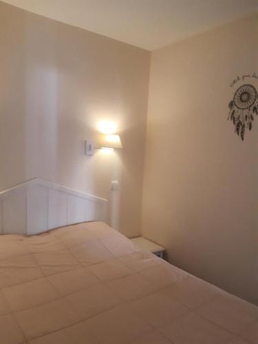 une chambre avec un lit avec une lumière sur le mur dans l'établissement Village Pont Royal en Provence - maeva Home - Appartement 2 pièces 7 personnes Sélection MAE-2092, à Mallemort