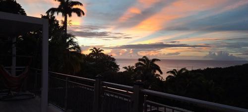 a sunset view of the ocean from a balcony at Domaine Choco Vanille in Deshaies