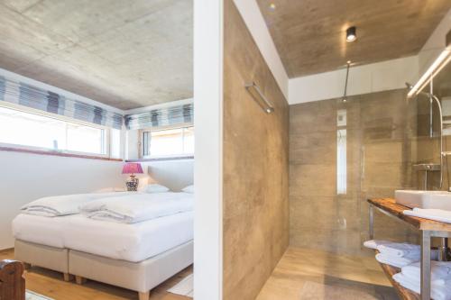 a bedroom with a bed and a bathroom with a sink at Winzarei Ciringa Stampfer in Svečina