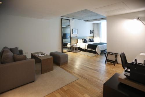 a living room with a couch and a bed at Anselmo Buenos Aires, Curio Collection by Hilton in Buenos Aires