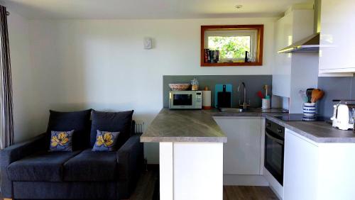 a kitchen with a couch next to a kitchen counter at Longtails Lodge, near Bantham in Bantham