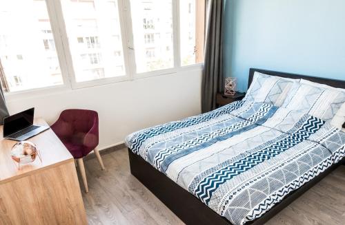 une chambre avec un lit et un bureau avec un ordinateur portable dans l'établissement Cozy apartment - Montrouge, à Montrouge