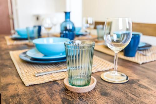 - une table en bois avec deux verres et des assiettes dans l'établissement Cozy apartment - Montrouge, à Montrouge