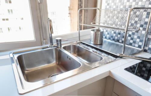 un évier en acier inoxydable dans une cuisine avec une fenêtre dans l'établissement Cozy apartment - Montrouge, à Montrouge