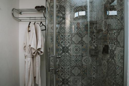 a shower with a glass door and towels in a bathroom at La Finca de Vane in Valle de Guadalupe