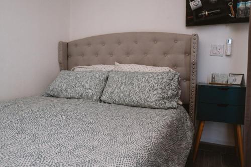 a bed with two pillows on it in a bedroom at La Finca de Vane in Valle de Guadalupe