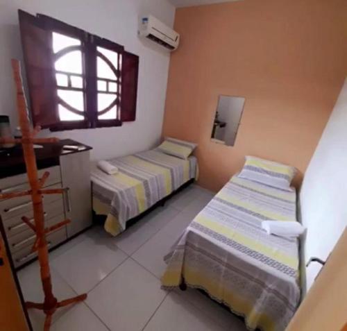 two beds in a room with a window at Casa de Praia na rota de Milagres - Praia de Marceneiro in Passo de Camarajibe
