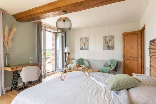 a bedroom with a bed and a desk and a window at Le gîte du Papillon - Normandy Holiday Cottage in Neufchâtel-en-Bray
