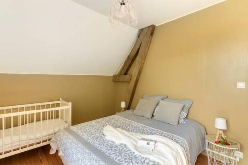 a bedroom with a bed with a white bedspread at Le gîte du Papillon - Normandy Holiday Cottage in Neufchâtel-en-Bray