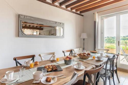 a dining room with a table with food on it at Le gîte du Papillon - Normandy Holiday Cottage in Neufchâtel-en-Bray