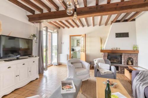 a living room with a tv and a fireplace at Le gîte du Papillon - Normandy Holiday Cottage in Neufchâtel-en-Bray