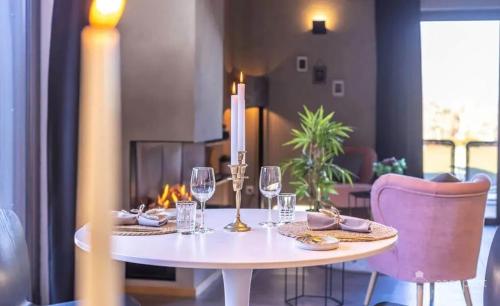 a white table with wine glasses and a candle on it at House with Jacuzzi in Gouvy / 80 m² in Wattermal