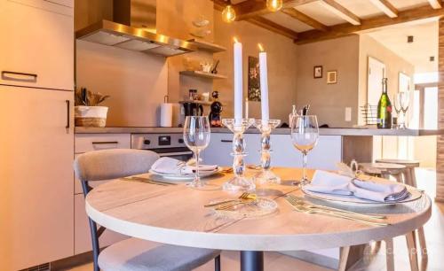 una mesa con copas de vino en la cocina en Cozy House with Jacuzzi in Gouvy, en Gouvy
