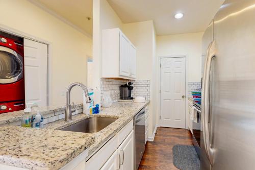 The PlantationsにあるCreekwood --- 200 Pebble Dr, Unit #213のシンクと冷蔵庫付きのキッチン