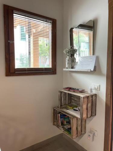 a shelf in a room with a mirror and a window at Una Casetta InterVineas in Spoleto