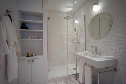a white bathroom with a shower and a sink at Relais12bis Bed & Breakfast By Eiffel Tower in Paris