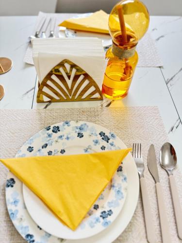 une table avec une plaque et une serviette jaune dans l'établissement New,mountain & sea view 3 guests with private Garage, à Beausoleil
