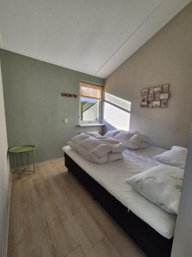 a bedroom with a large bed and a window at De Vos in Tzummarum