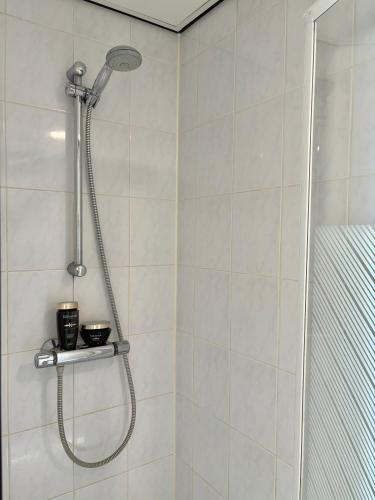 eine Dusche mit Duschkopf in einem Badezimmer in der Unterkunft Yellow Bliss Apartment Makkum Beach in Makkum