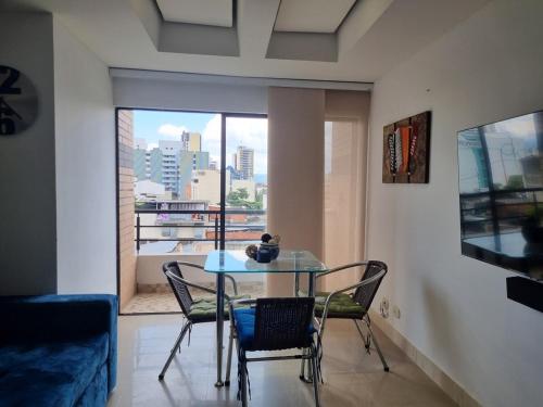 a table and chairs in a living room with a window at Infante Loft 402P - WAIWA HOST in Bucaramanga
