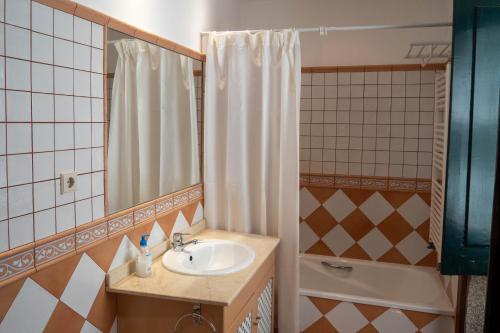 a bathroom with a sink and a shower and a mirror at Casa de Vilela - casa senhorial exclusiva perto do Porto para até 15 pessoas in Santo Tirso