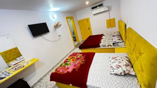 two beds in a room with a tv and a bed sidx sidx sidx at The Ortus Suites by BnBGuys in Orchha