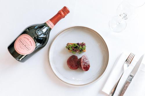 a bottle of wine next to a plate of food at InterContinental London - The O2 in London