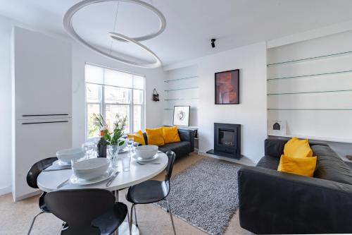 a living room with a white table and yellow pillows at Swift Host - Sleeps 4 - Apartment - Great Location - Parking in Norwich