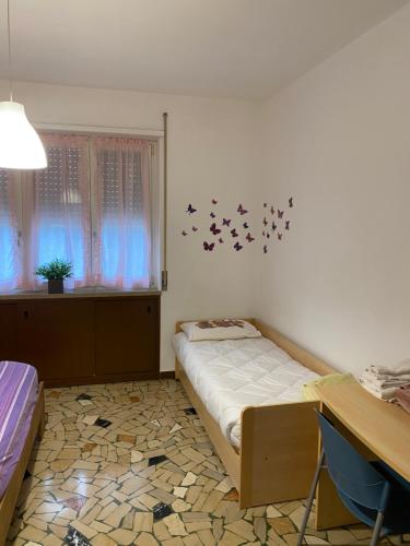 a bedroom with a bed and a window with birds on the wall at Appartamento " Le Farfalle " in Santorso