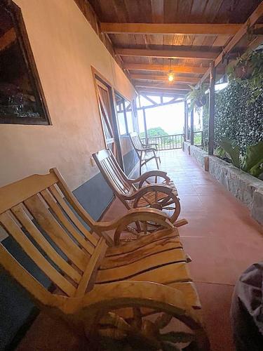 two wooden chairs sitting on the porch of a house at Casa Típica La Cruz in Monteverde Costa Rica