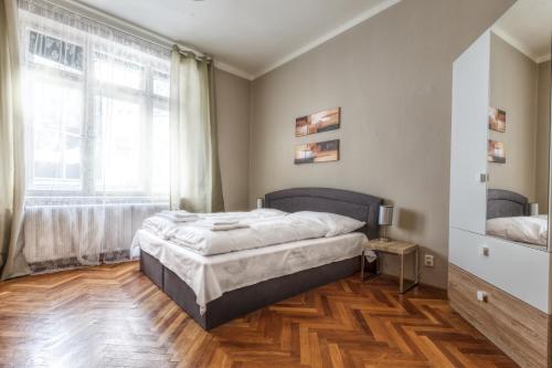 a bedroom with a bed and a large window at Modern Apartment Biskupska in Prague