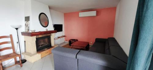 un salon avec un canapé et une cheminée dans l'établissement Appartement vue mer, pietranera, à San-Martino-di-Lota