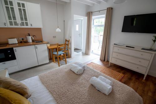 a kitchen and a living room with towels on a bed at The Oak Studio-Kilpatrick Glebe, Pet Friendly in Wexford