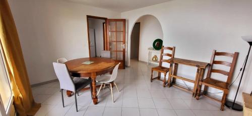 une salle à manger avec une table et des chaises en bois dans l'établissement Appartement vue mer, pietranera, à San-Martino-di-Lota