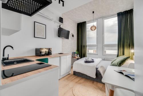 Una cocina con fregadero y una sala de estar. en Stylove Sunset, en Opole