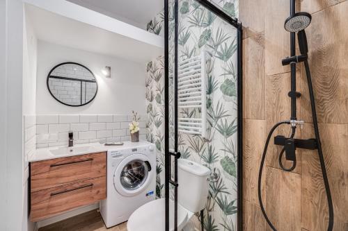 baño con lavadora y secadora junto a un aseo en Stylove Sunset, en Opole