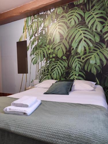 a bedroom with a bed with a plant wall at Hotel de la Place in Loyettes