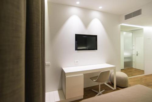 a bedroom with a desk and a television on a wall at Best Western Hotel Biri in Padova