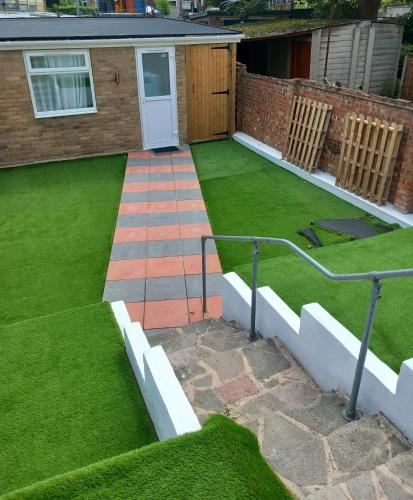 a garden with green grass and a white door at 3 Guests - 1 Bedroom in Erith